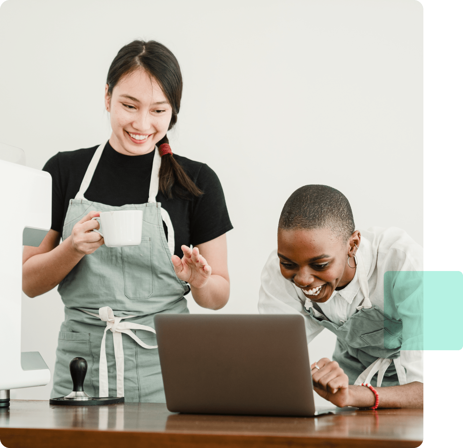 smiling-cafe-workers-looking-at-laptop